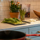 a kitchen counter with a potted plant and a cutting board